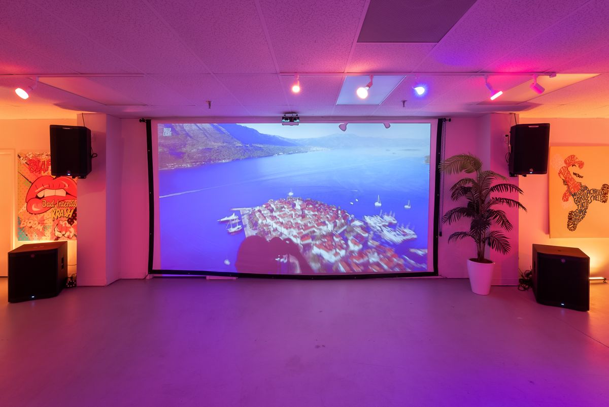 Large projection screen with speakers for presentations