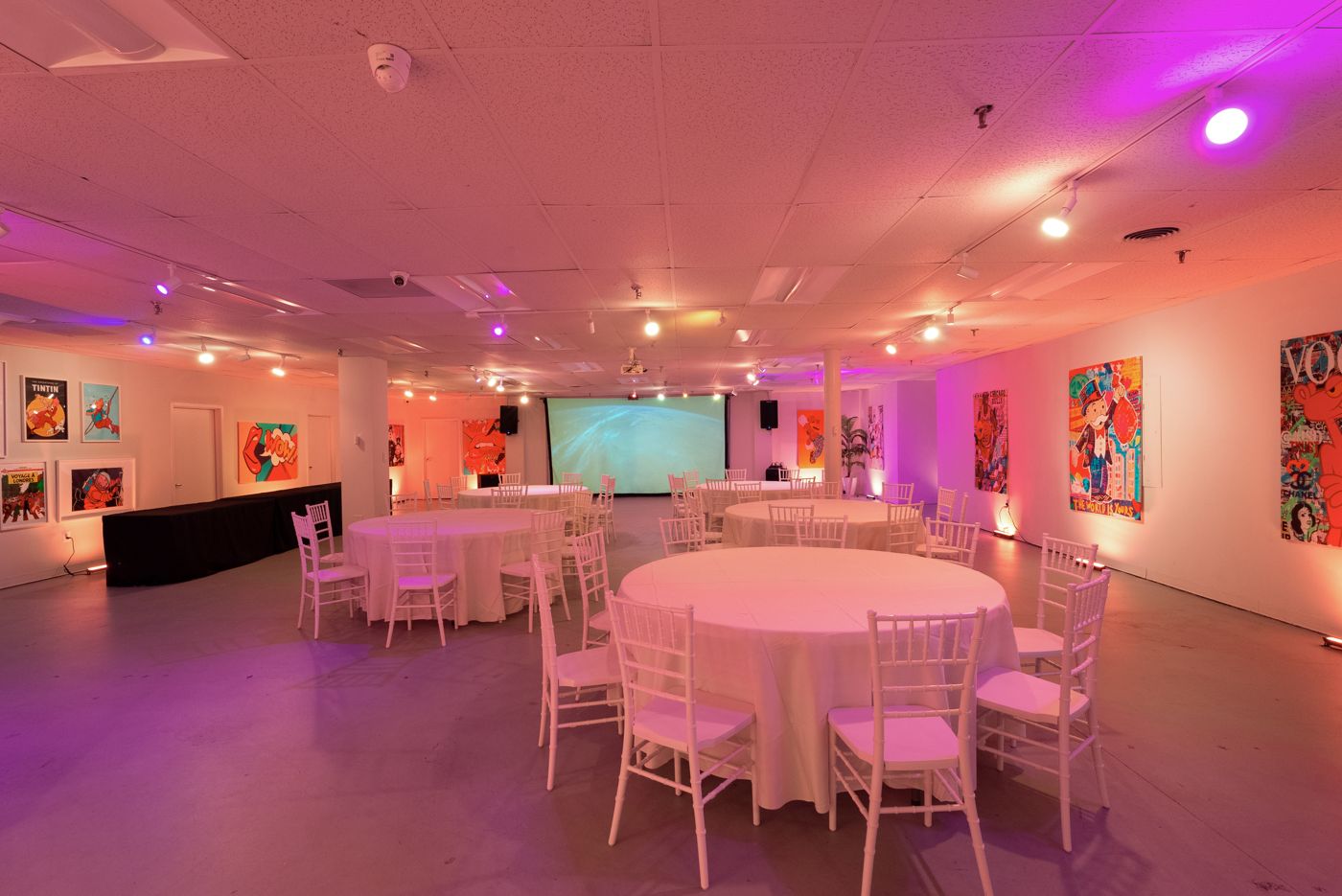 Dinner setup with round tables and white chairs